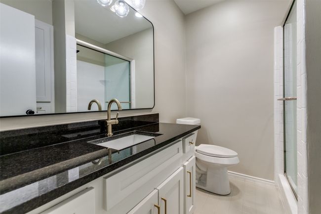 Full bathroom with vanity, a shower with door, and tile patterned floors | Image 30