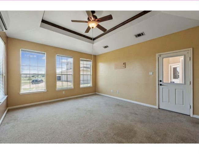 Spare room with a raised ceiling, carpet, plenty of natural light, and ceiling fan | Image 11