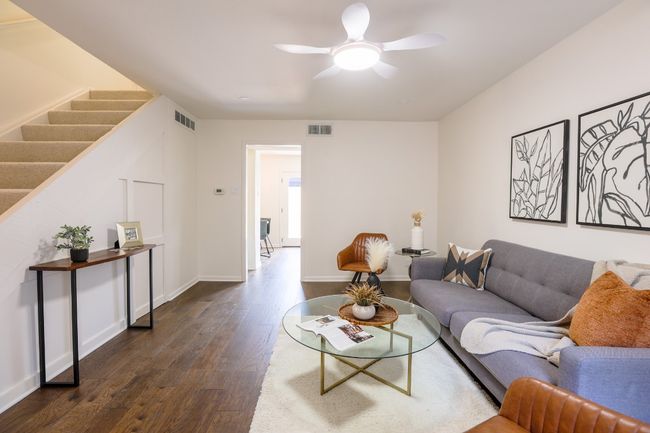Living area with dark engineered hardwood floors and ceiling fan. | Image 33