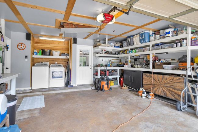This versatile garage features built-in shelving, providing convenient storage for tools, gear, and household essentials. A rear door offers direct access to the kitchen, making grocery hauls or quick clean-ups easier than ever. | Image 28