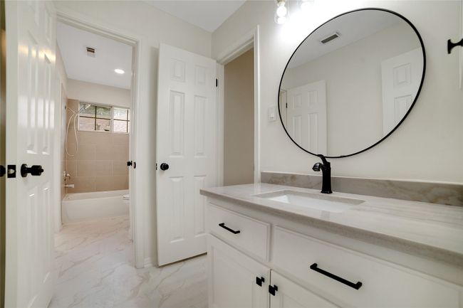 Full bath with vanity, shower / tub combination, marble finish floors, and toilet | Image 19