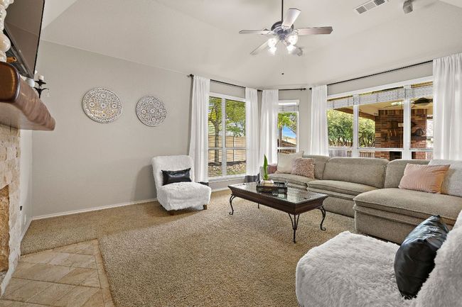 Carpeted living area with ceiling fan and baseboards | Image 8