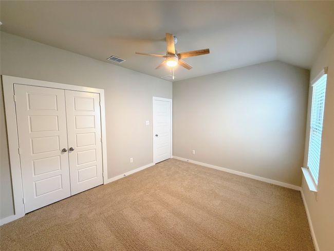 Unfurnished bedroom with carpet flooring, a closet, baseboards, a ceiling fan, and vaulted ceiling | Image 25