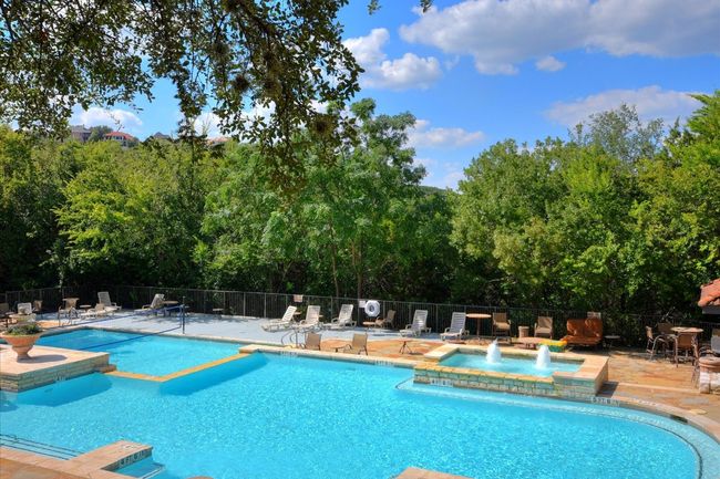 Community pool featuring a community hot tub, a patio area, and view of scattered trees | Image 18