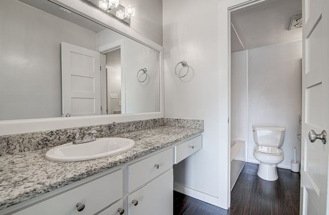 Full bathroom featuring vanity, toilet, shower / bath combination, wood finished floors, and baseboards | Image 18