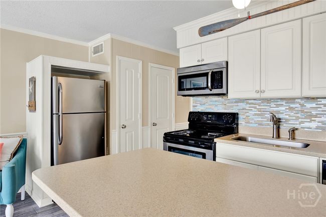 Full Sized Kitchen with Stainless Steel Appliances, Ceiling Height Cabinets, Island with Barstool Seating & Pantry. | Image 13