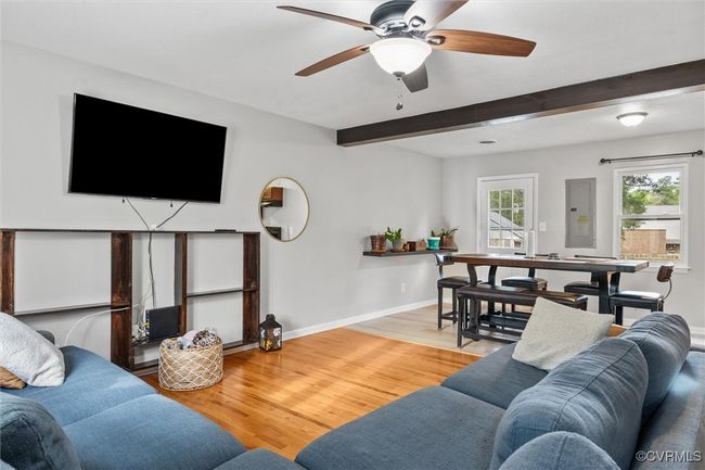 Living room with baseboards, beamed ceiling, ceiling fan, and light wood finished floors | Image 7