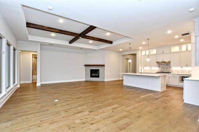 Unfurnished living room featuring coffered ceiling, light wood-type flooring, baseboards, beamed ceiling | Image 9