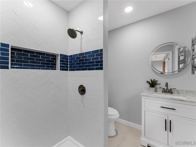 Full bathroom featuring baseboards, a tile shower, vanity, and toilet | Image 26