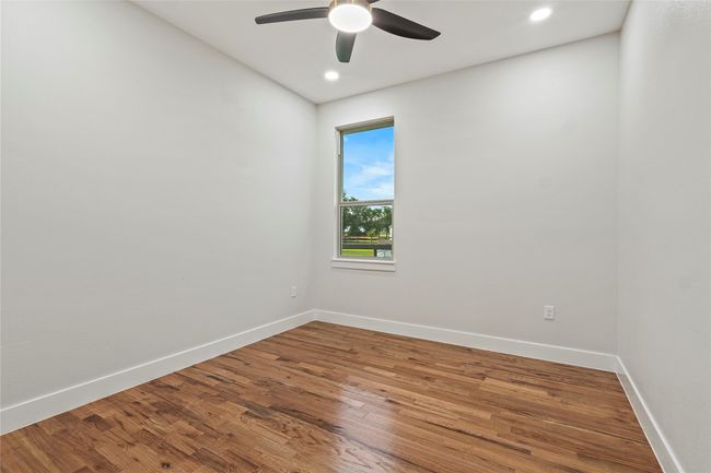 Empty room with ceiling fan, wood finished floors, and recessed lighting | Image 21