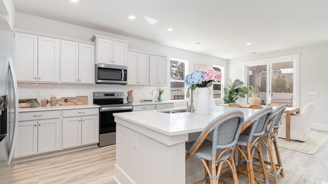 Kitchen featuring stainless steel appliances, a sink, healthy amount of natural light, a kitchen island with sink, and recessed lighting | Image 10