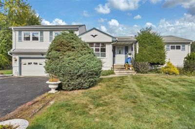 View of front facade with a front yard and a garage | Image 1