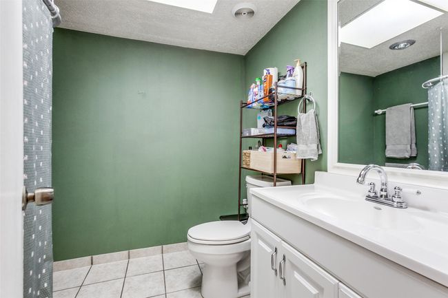 Full bathroom with a skylight, vanity, tile patterned floors, and a textured ceiling | Image 10