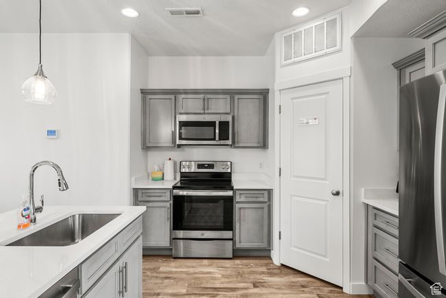 Kitchen featuring a sink, stainless steel appliances, visible vents, and gray cabinets | Image 6