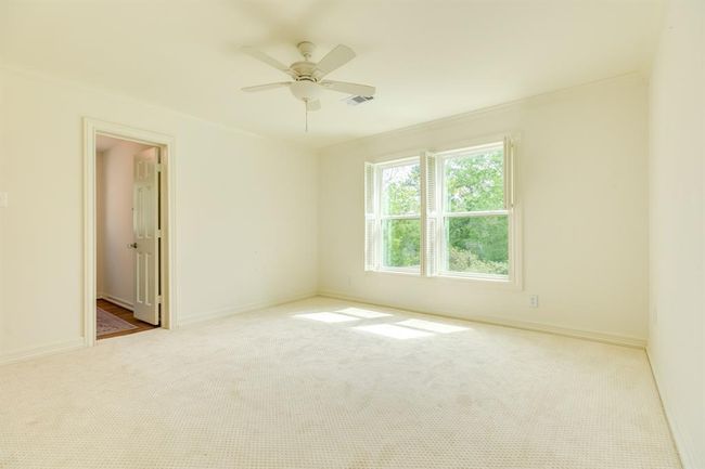 The third secondary bedroom includes an attached half bath and features two windows overlooking the backyard and pool. | Image 32