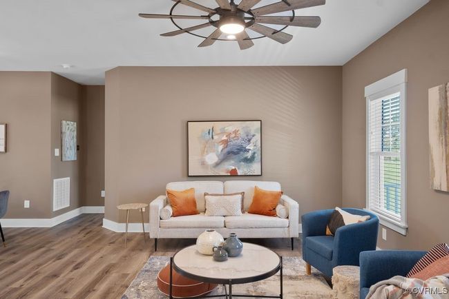 Living room featuring visible vents, baseboards, a ceiling fan, and wood finished floors | Image 5
