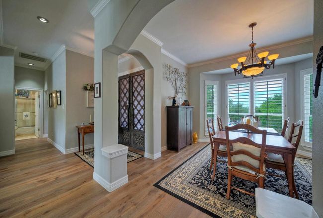 Dining area featuring a chandelier, arched walkways, light wood finished floors, and plenty of natural light | Image 7