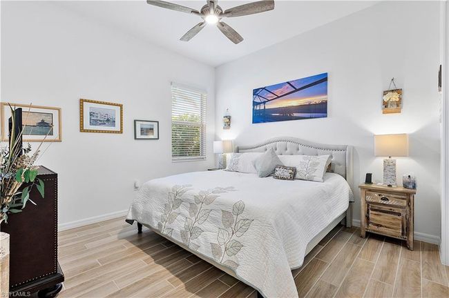 Bedroom with baseboards, a ceiling fan, and wood tiled floor | Image 41