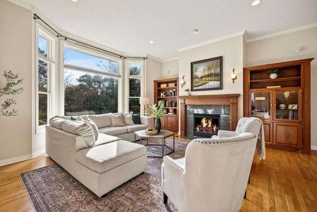 Spacious living room featuring a gas fireplace with a picturesque view of a stunning wooded lot. | Image 4