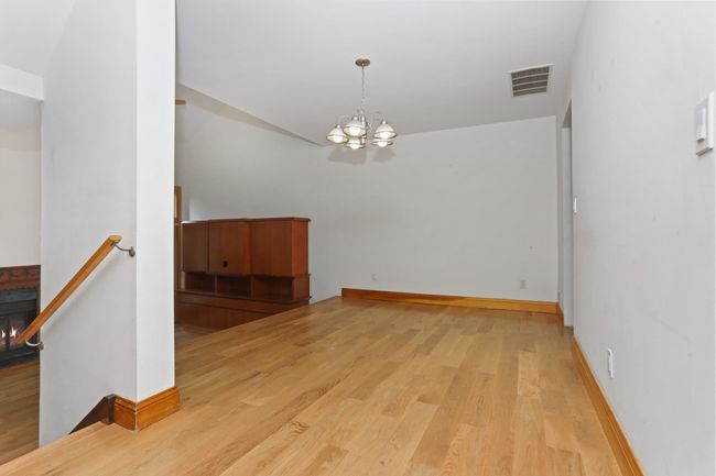 Spare room with a chandelier, wood finished floors, and baseboards | Image 16