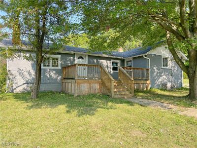 Back of house with a lawn and a deck | Image 1