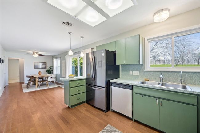 Kitchen featuring a sink, light countertops, green cabinetry, and stainless steel appliances | Image 9