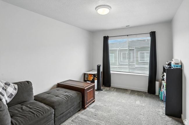 Bedroom featuring light carpet and a textured ceiling | Image 14