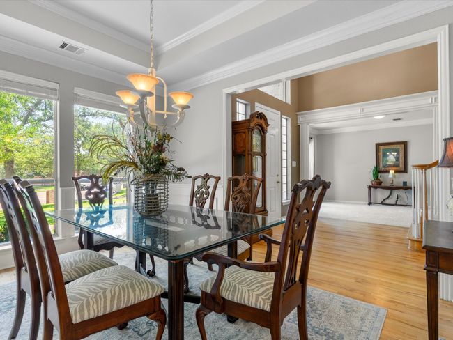 Dining area featuring healthy amount of natural light, light wood-type flooring, a chandelier, and crown molding | Image 8