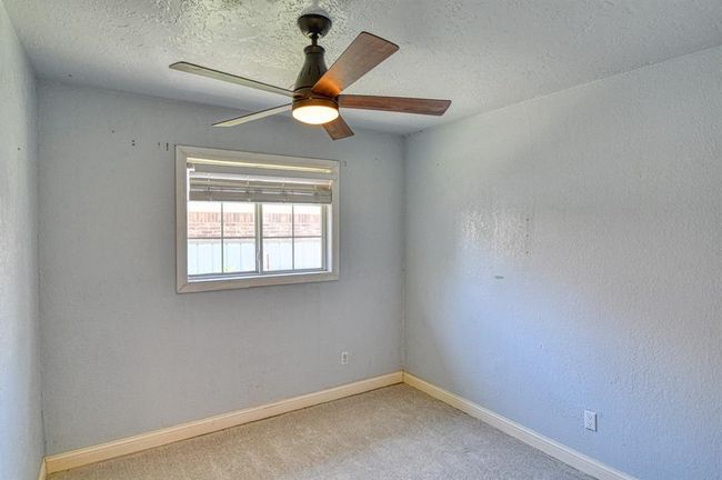 Unfurnished room with a ceiling fan, baseboards, carpet flooring, and a textured ceiling | Image 21