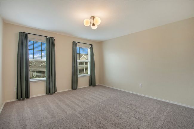 Carpeted spare room with baseboards and a chandelier | Image 27