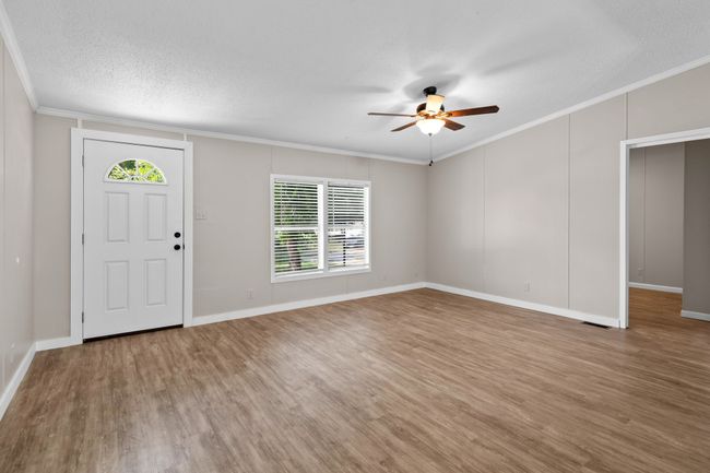 Entrance foyer with ceiling fan, wood finished floors, ornamental molding, and a textured ceiling | Image 15