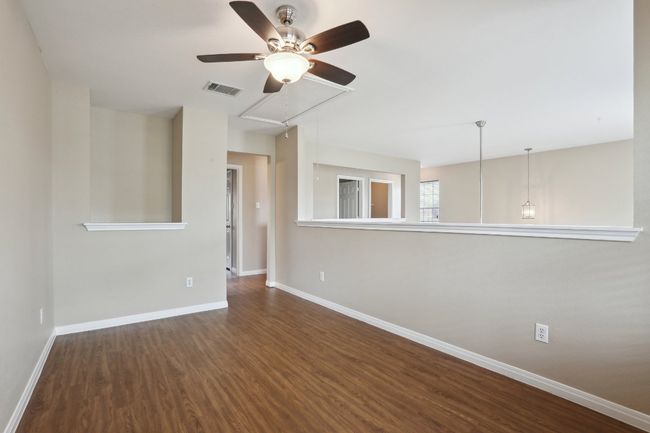 Unfurnished room featuring visible vents, baseboards, attic access, wood finished floors, and a ceiling fan | Image 32