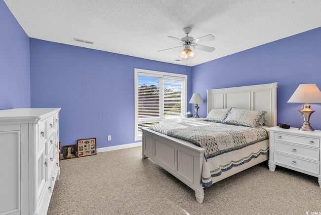Bedroom featuring light colored carpet, a ceiling fan, a textured ceiling, and visible vents | Image 12