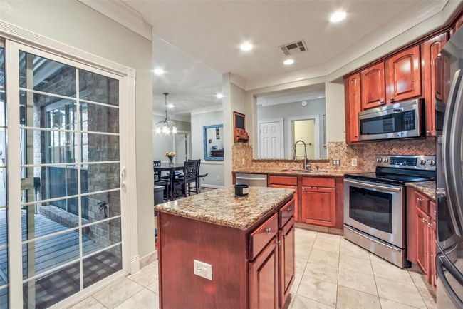 Spacious kitchen features granite countertops and stainlesss appliances. | Image 8