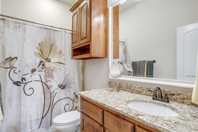 Bathroom featuring toilet, vanity, and a shower with curtain | Image 24