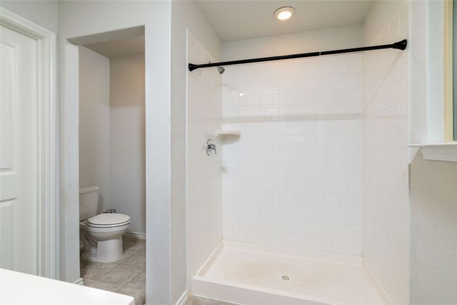 Full bath with toilet, tiled shower, and tile patterned floors | Image 23