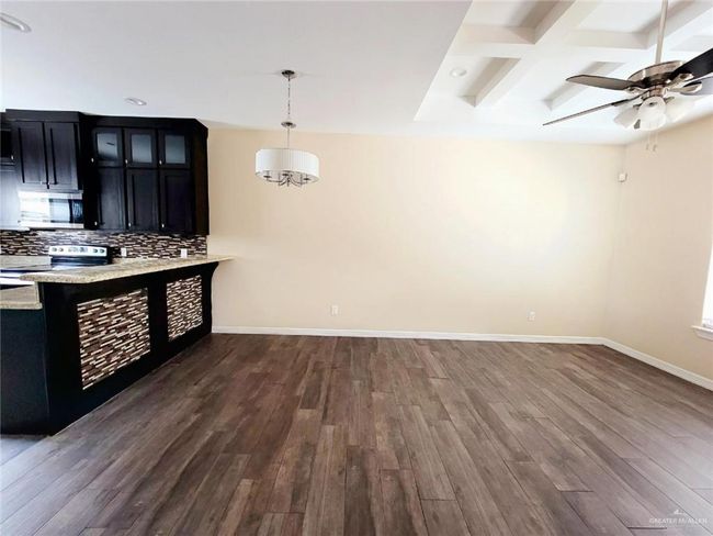 Kitchen with appliances with stainless steel finishes, dark cabinetry, dark wood finished floors, tasteful backsplash, and beamed ceiling | Image 10