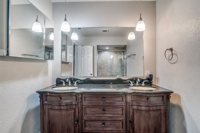 Full bath featuring a shower stall, double vanity, and a textured wall | Image 22