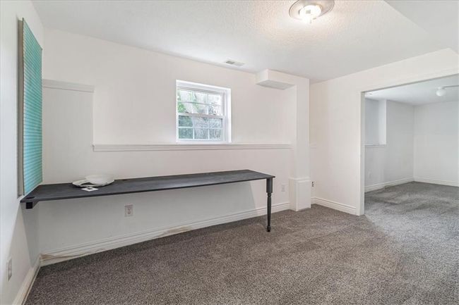 Spare room featuring carpet floors, baseboards, a textured ceiling, and visible vents | Image 44