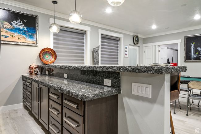 Bar featuring crown molding, hanging light fixtures, and recessed lighting | Image 68