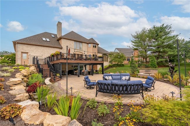 This is a view of the rear of property. This is just a few years old. Look at the beautiful barn stone, spacious patio and notice the covered porch with screens. | Image 6