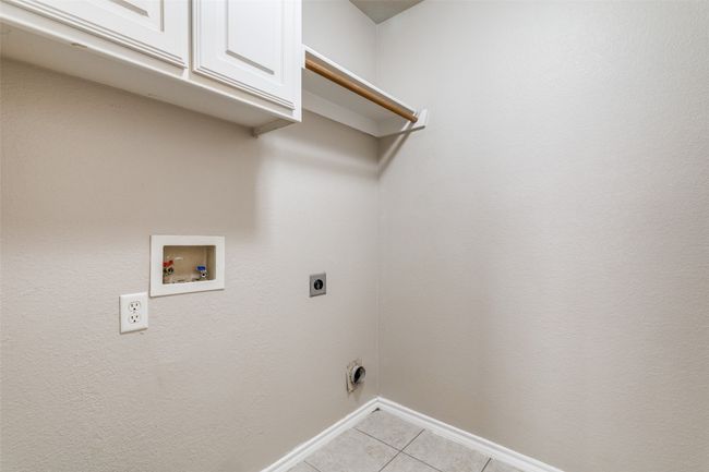 Laundry room with cabinet space, electric dryer hookup, washer hookup, and light tile patterned flooring | Image 19