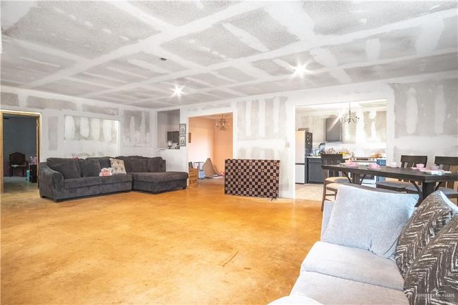 Living area featuring finished concrete flooring and a chandelier | Image 4