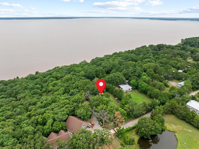 Aerial view of a nearby body of water and a heavily wooded area | Image 7