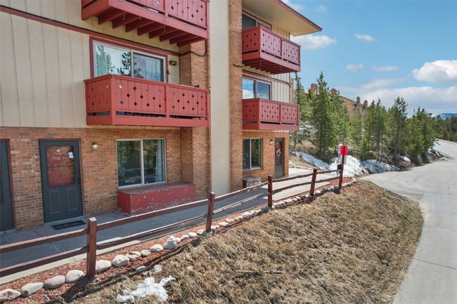 View of property exterior featuring brick siding, a balcony, and fence | Image 27