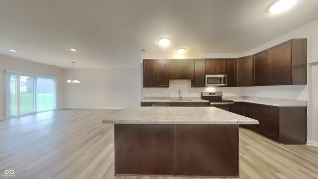 kitchen featuring light wood-style flooring, a sink, a chandelier, stainless steel appliances, and dark brown cabinetry | Image 7