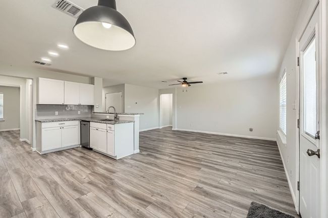 Kitchen with dishwasher, baseboards, visible vents, a sink, and a peninsula | Image 5