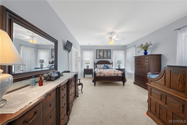 Bedroom featuring light colored carpet and ceiling fan | Image 23