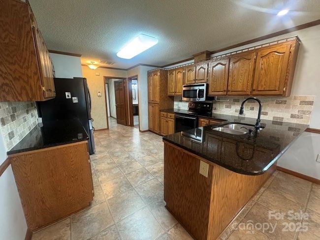 Lots of cabinet space with tile backsplash | Image 15