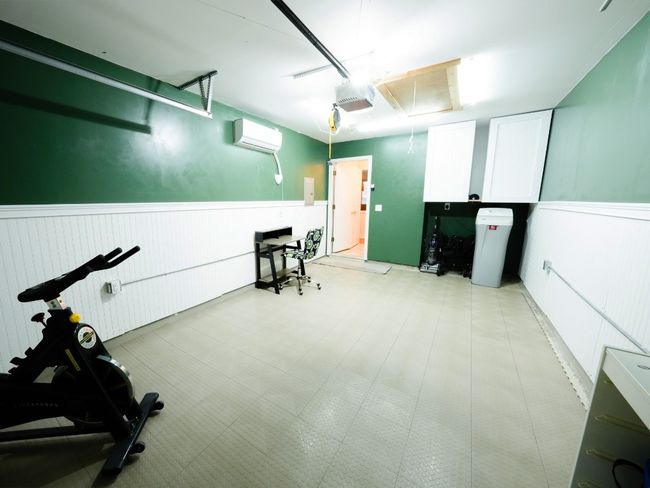 Exercise room featuring a garage, a wainscoted wall, attic access, and an AC wall unit | Image 17